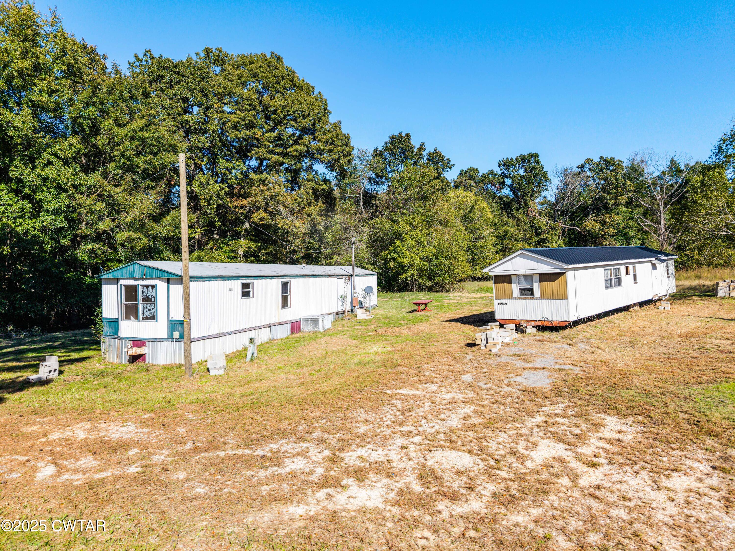 0 Charles Lane Cedar Grove, TN 38321 - Photo 13 of 16 a white house with a yard and large trees