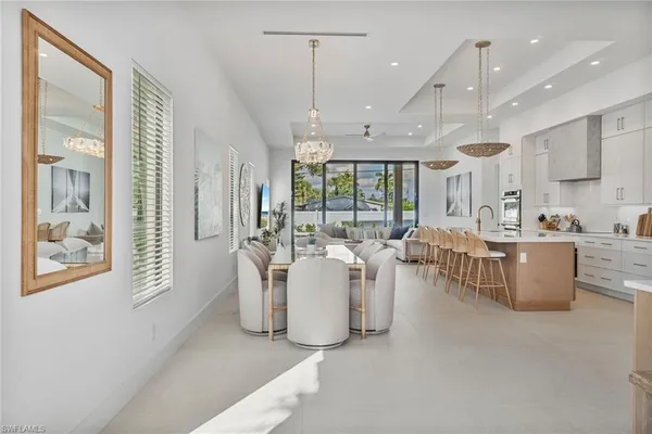 a living room with couches and kitchen view with wooden floor