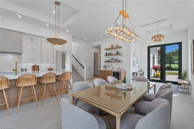 a dining room with furniture a chandelier and window