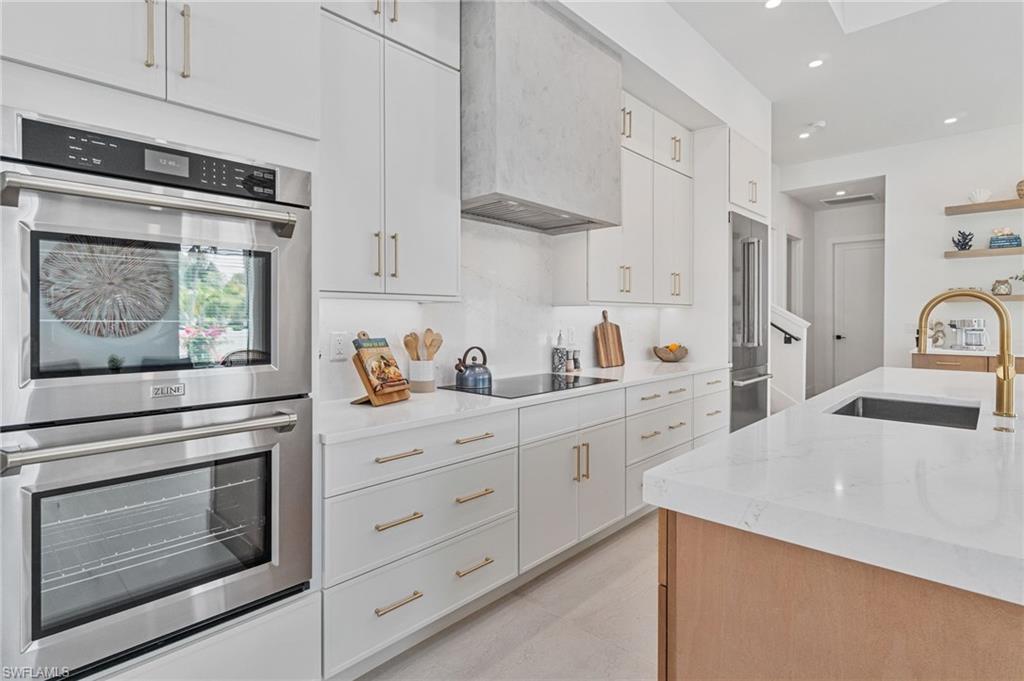 803 96th Avenue North Naples, FL 34108 - Photo 19 of 50 a kitchen with granite countertop white cabinets and white appliances