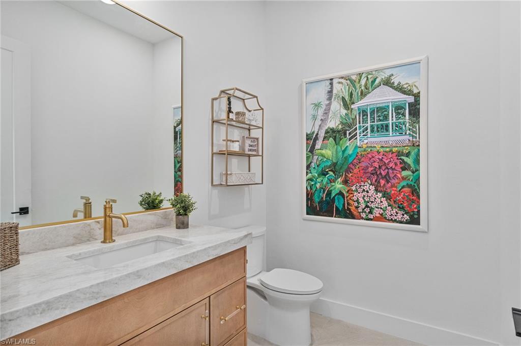 803 96th Avenue North Naples, FL 34108 - Photo 21 of 50 a bathroom with a granite countertop sink mirror vanity and toilet