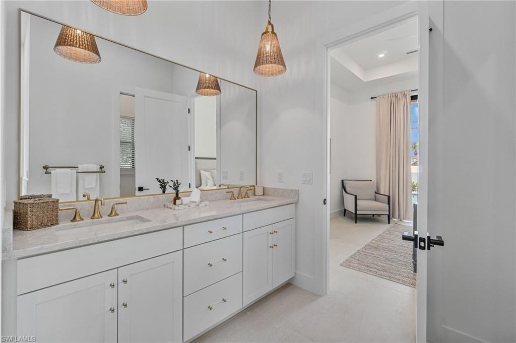803 96th Avenue North Naples, FL 34108 - Photo 26 of 50 a en suite bathroom with double sink and a mirror