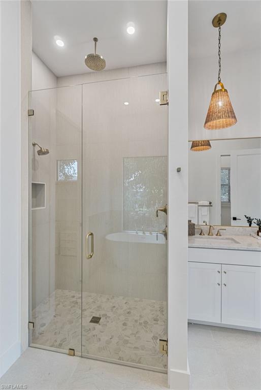 803 96th Avenue North Naples, FL 34108 - Photo 27 of 50 a bathroom with a granite countertop sink a mirror and a glass door shower