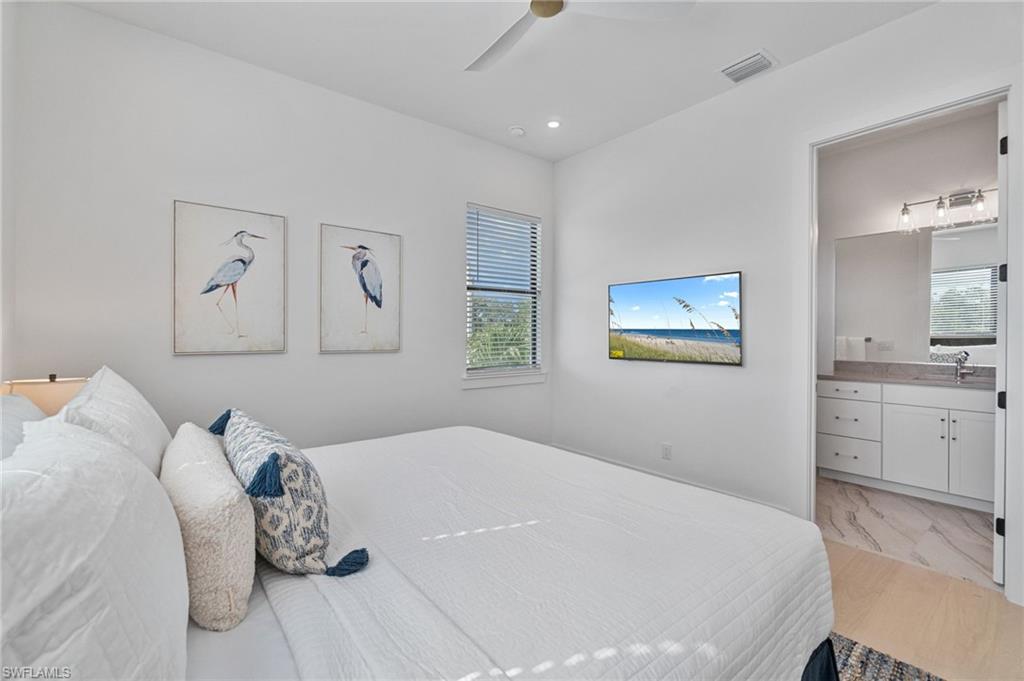 803 96th Avenue North Naples, FL 34108 - Photo 30 of 50 a bedroom with a large bed and a chandelier