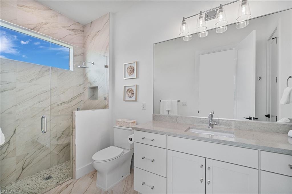 803 96th Avenue North Naples, FL 34108 - Photo 31 of 50 a bathroom with a granite countertop toilet sink and mirror