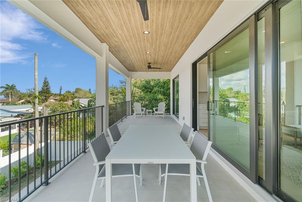 803 96th Avenue North Naples, FL 34108 - Photo 40 of 50 a view of a balcony with furniture and floor to ceiling window