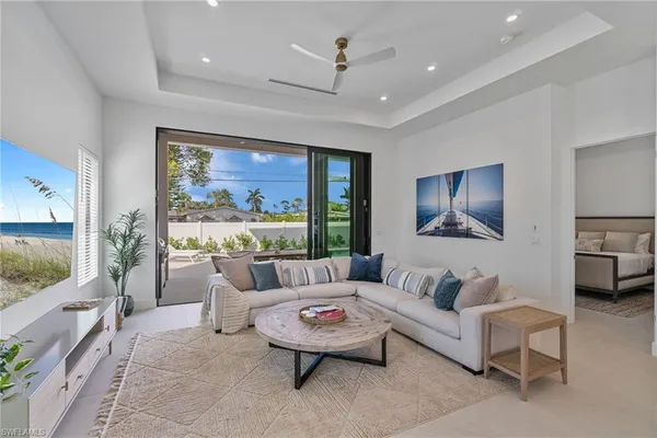 a living room with furniture a flat screen tv and a large window