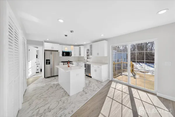 a large white kitchen with white cabinets and stainless steel appliances