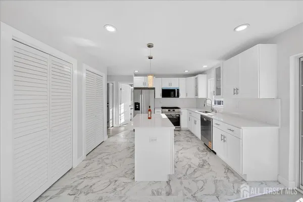 a large white kitchen with white cabinets and white appliances