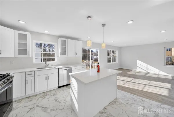 a large kitchen with kitchen island a sink stainless steel appliances and cabinets