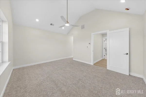an empty room with fan and windows