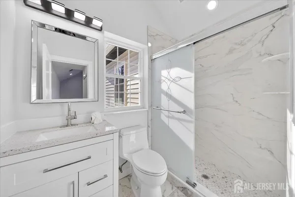a bathroom with a granite countertop sink toilet and shower