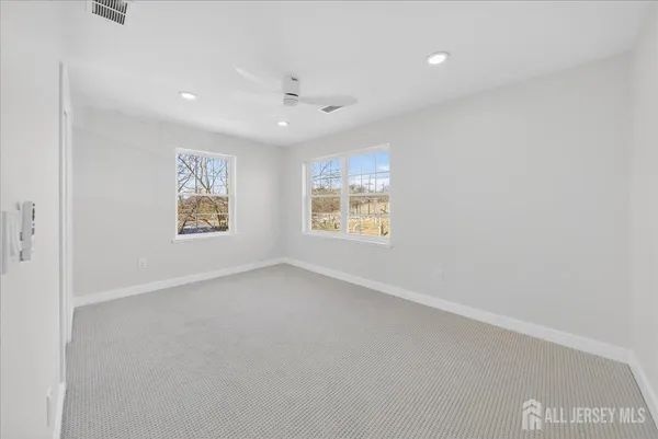 an empty room with closet and a ceiling fan