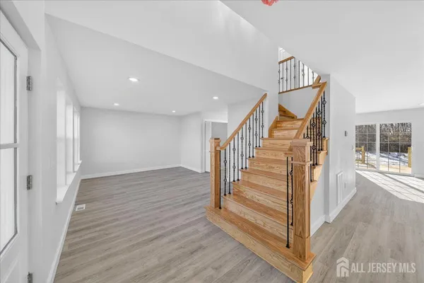 a view of a hallway with wooden floor and staircase