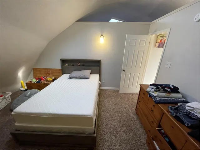 a bedroom with a bed and a lamp with wooden floor
