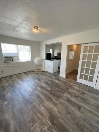a view of an empty room with a window and fireplace