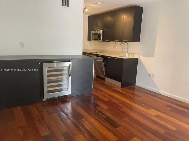 a view of a livingroom with wooden floor and a bathroom
