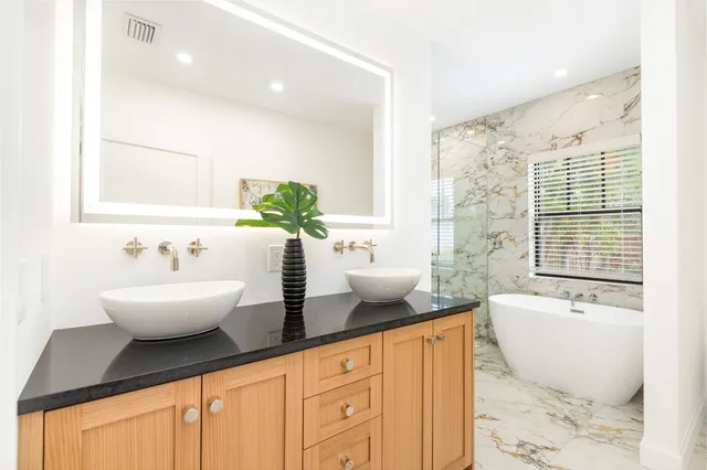 a bathroom with a granite countertop sink and a bathtub