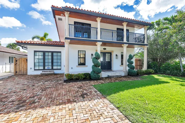 a front view of a house with a garden and plants