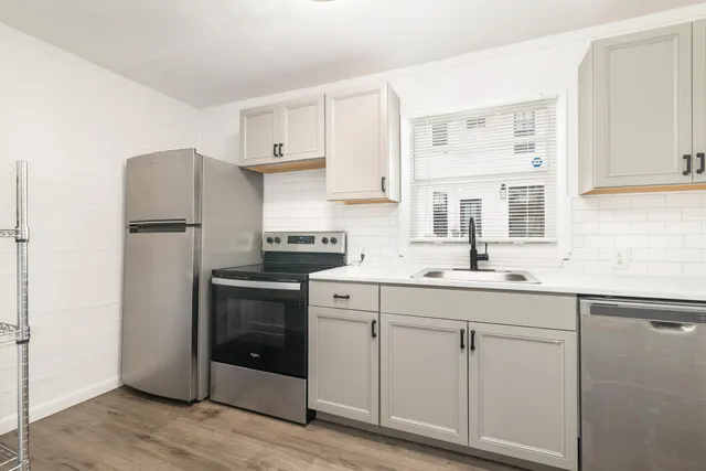 a kitchen with white cabinets and white appliances
