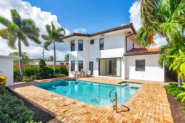 a view of a house with swimming pool and sitting area
