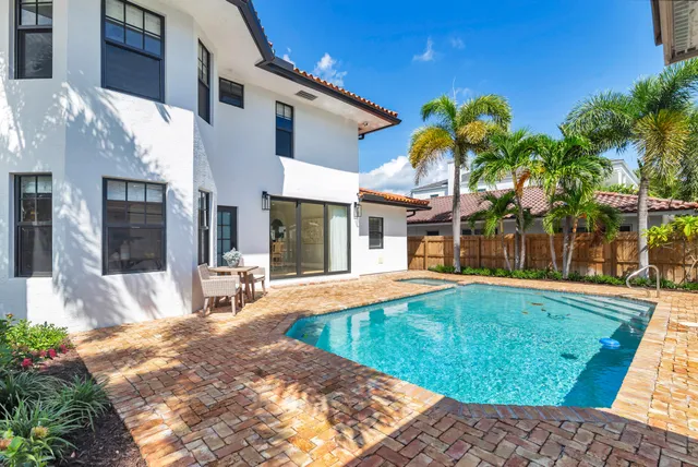 a view of a house with a swimming pool and sitting area