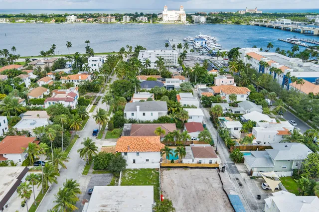 an aerial view of a city with lots of residential buildings ocean and mountain view in back