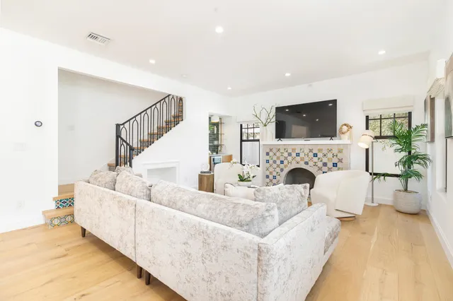a living room with furniture a flat screen tv and a fireplace