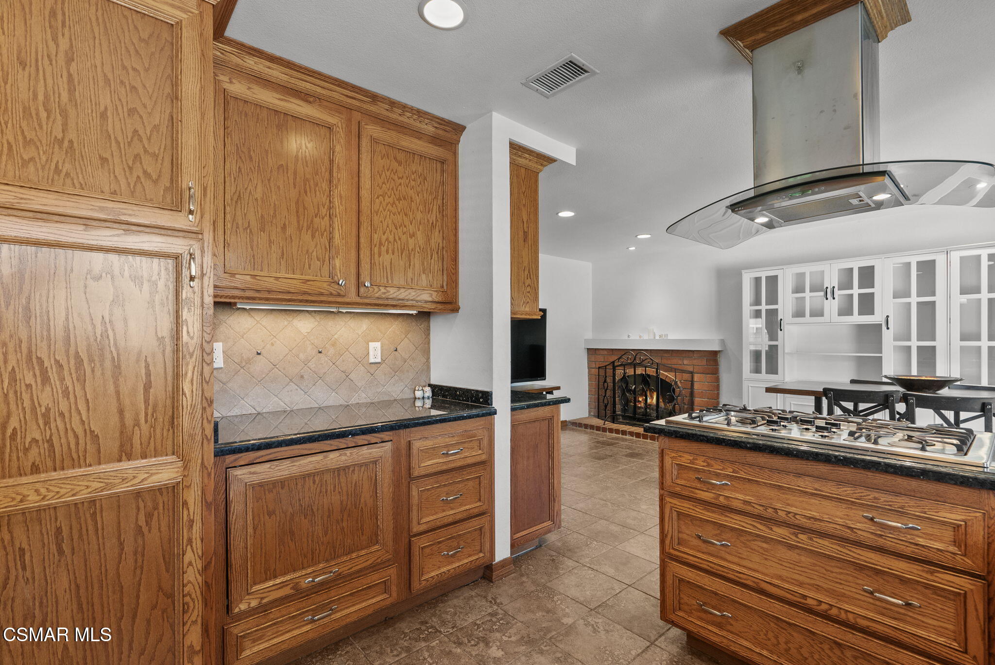 6435 Hazel Circle Simi Valley, CA 93063 - Photo 18 of 55 a kitchen with kitchen island granite countertop a refrigerator stove and cabinets