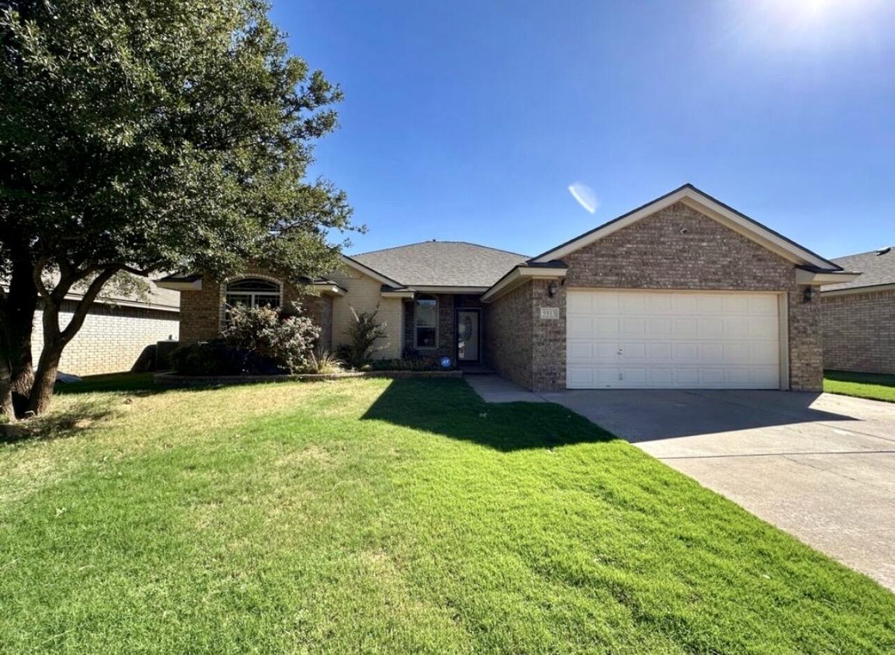 5513 104th Street Lubbock, TX 79424 - Photo 1 of 3 a front view of a house with a yard and garage