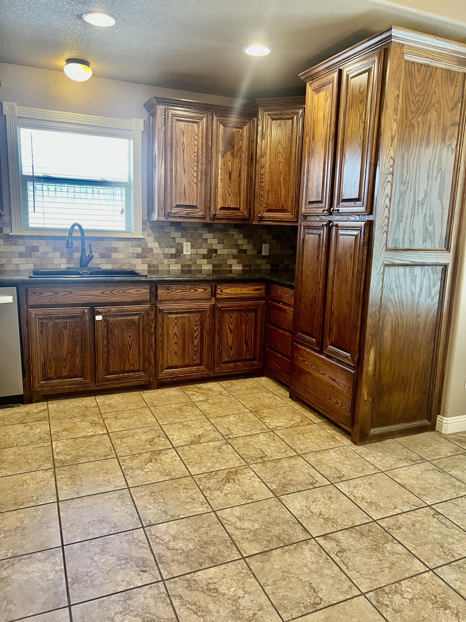 5513 104th Street Lubbock, TX 79424 - Photo 5 of 10 a kitchen with stainless steel appliances granite countertop a refrigerator and a sink