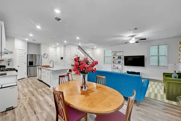 a living room with furniture a flat screen tv and kitchen view
