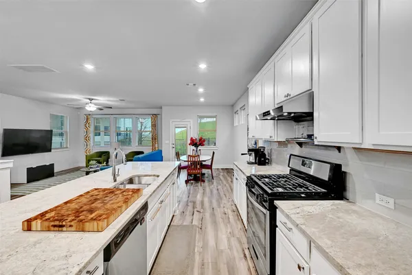 a large kitchen with stainless steel appliances granite countertop a lot of counter space and a sink
