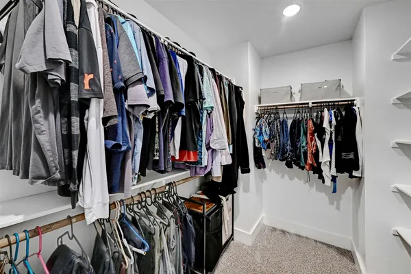 a view of walk in closet with clothes