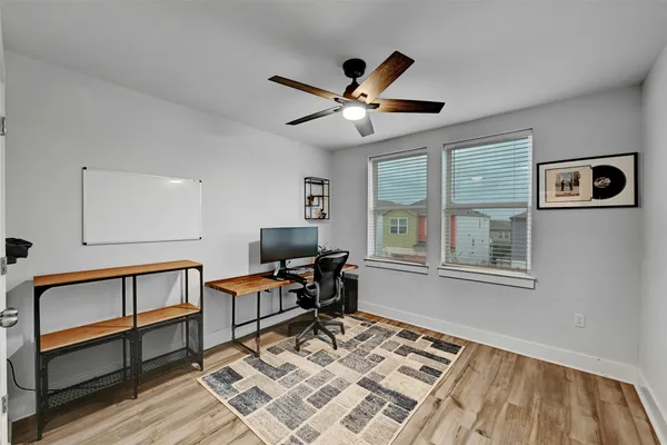 a workspace with wooden floor and windows