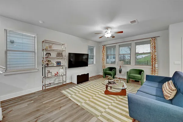 a living room with furniture a flat screen tv and a large window