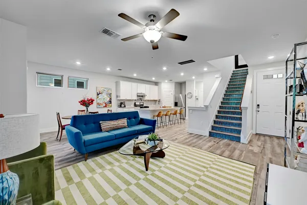 a living room with furniture and a ceiling fan