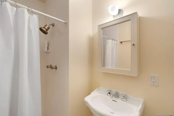 a bathroom with a sink a mirror and shower view