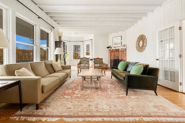 a living room with furniture wooden floor and wall painting