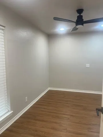 a view of a room with wooden floor and windows