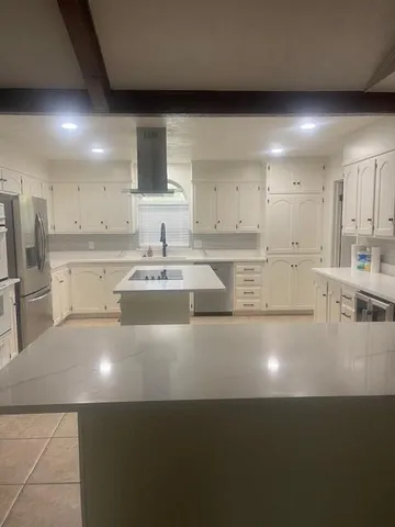 a kitchen with kitchen island sink stove and cabinets