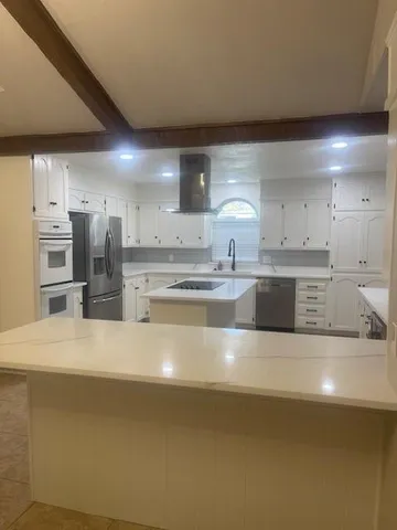 a large kitchen with stainless steel appliances and a refrigerator