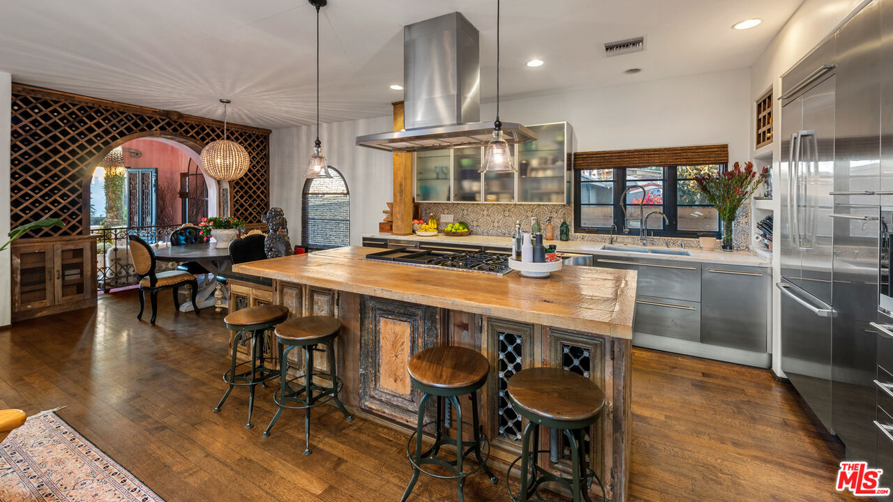 7546 Rindge Avenue Playa del Rey, CA 90293 - Photo 47 of 67 a kitchen with stainless steel appliances kitchen island granite countertop a table chairs sink and wooden floor