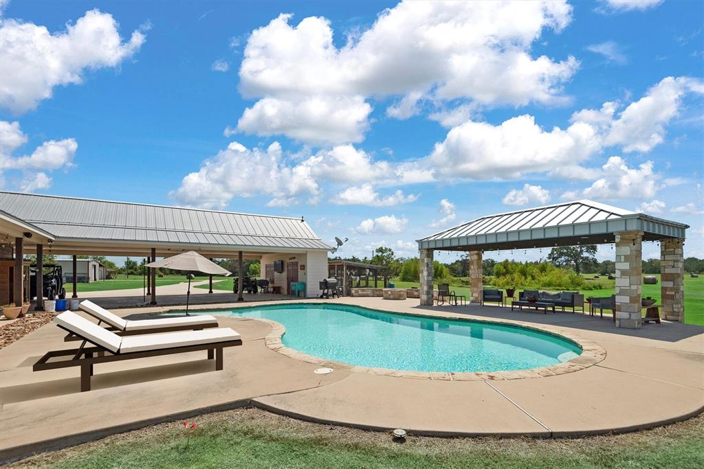 3759 Cr 126 Road Bedias, TX 77831 - Photo 18 of 38 a view of a swimming pool with a bench and lawn chairs