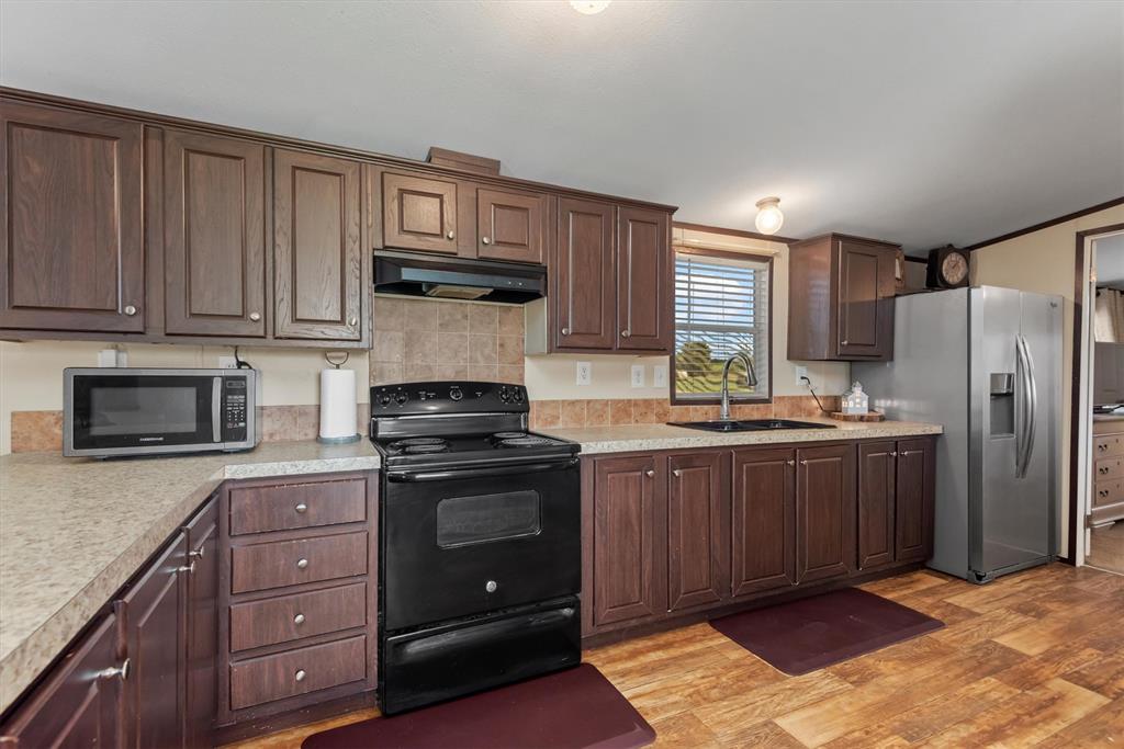 3759 Cr 126 Road Bedias, TX 77831 - Photo 28 of 38 a kitchen with stainless steel appliances granite countertop a stove a refrigerator and a microwave
