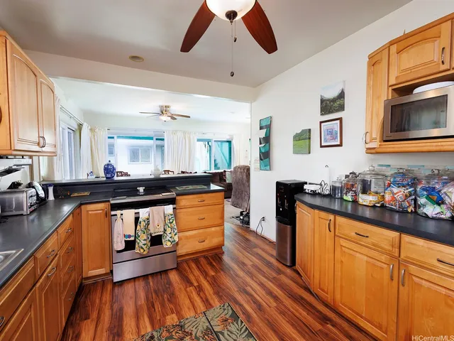 a kitchen with stainless steel appliances granite countertop a sink stove and wooden cabinets