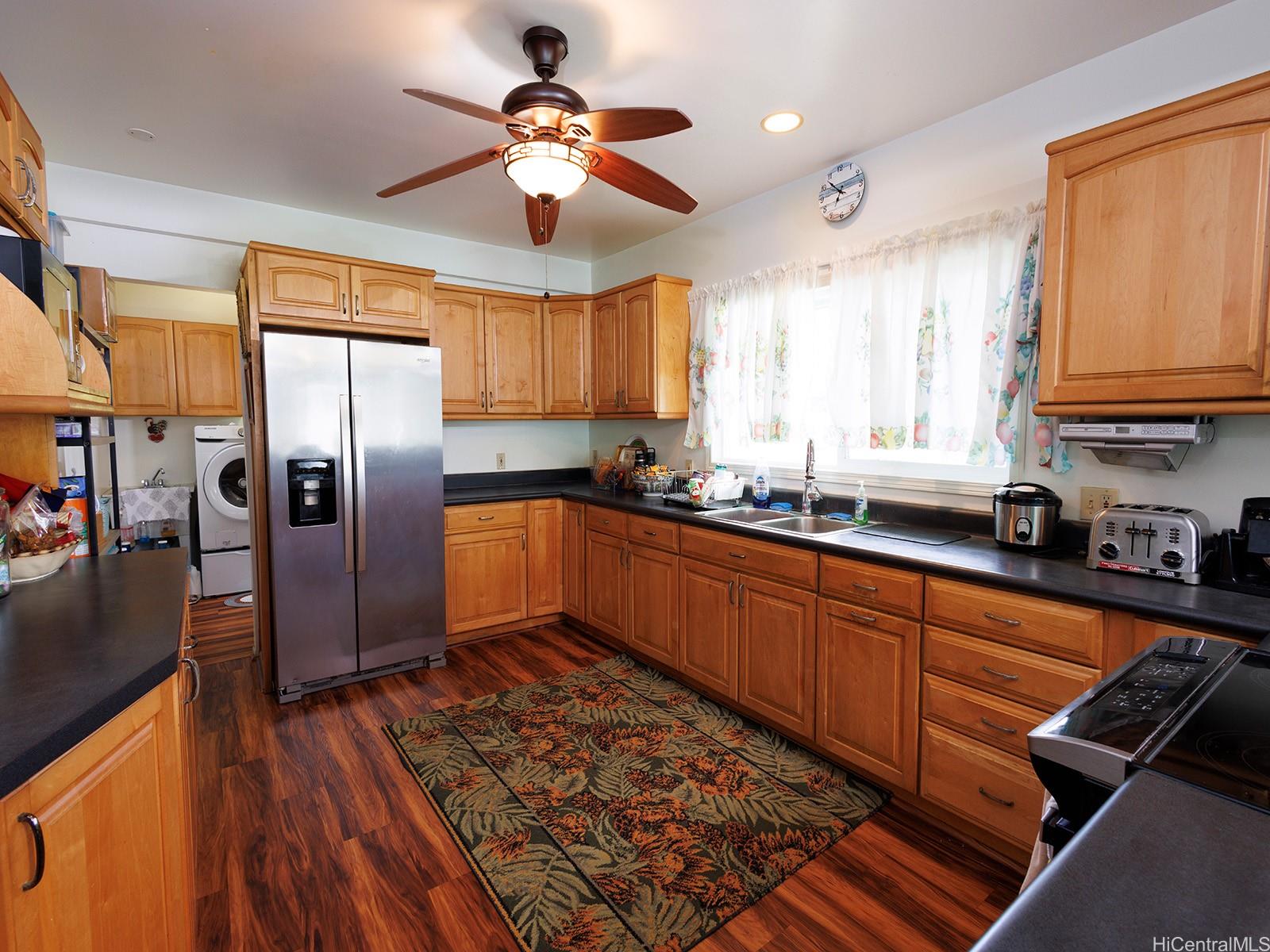 51-450 Kekio Road Kaaawa, HI 96730 - Photo 12 of 25 a kitchen with stainless steel appliances granite countertop a refrigerator a sink dishwasher a stove and white countertops with wooden floor