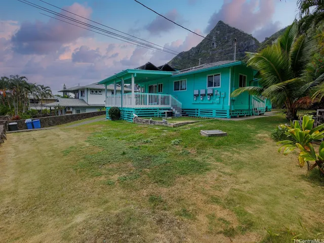 a view of a house with a swimming pool and sitting area