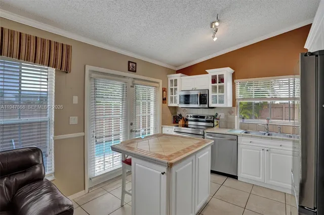 a kitchen with stainless steel appliances granite countertop a refrigerator and a stove