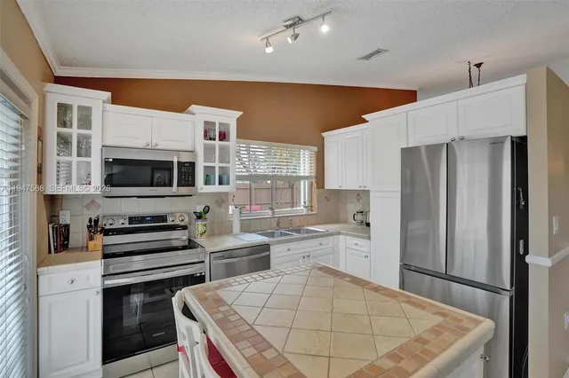 a kitchen with a stove a sink dishwasher and a refrigerator
